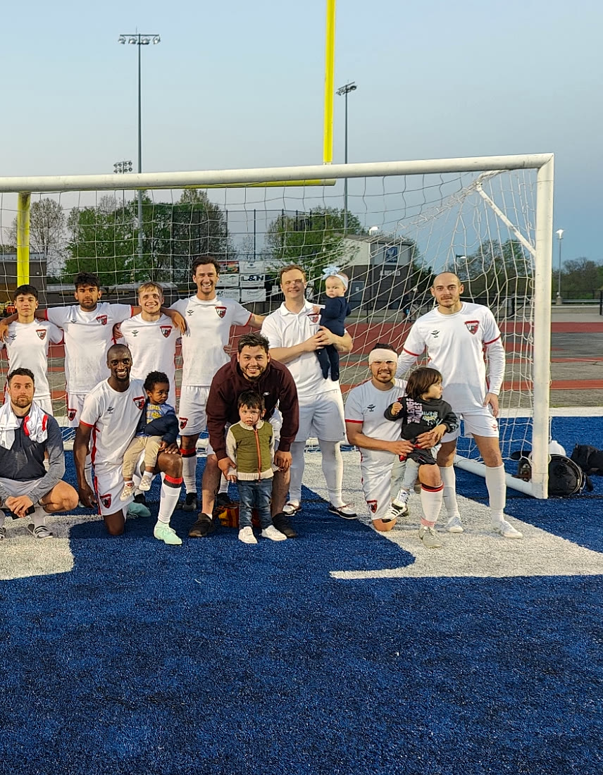 The Valhalla FC senior squad at the goal with the next generation in front